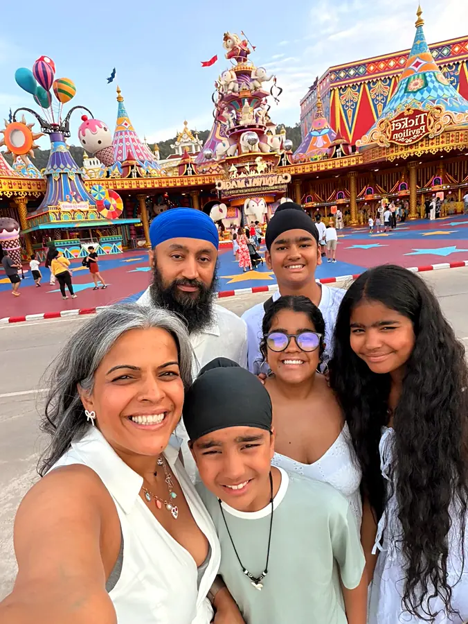 All six of the family squeezed into one selfie in front of the carnival gates at dusk